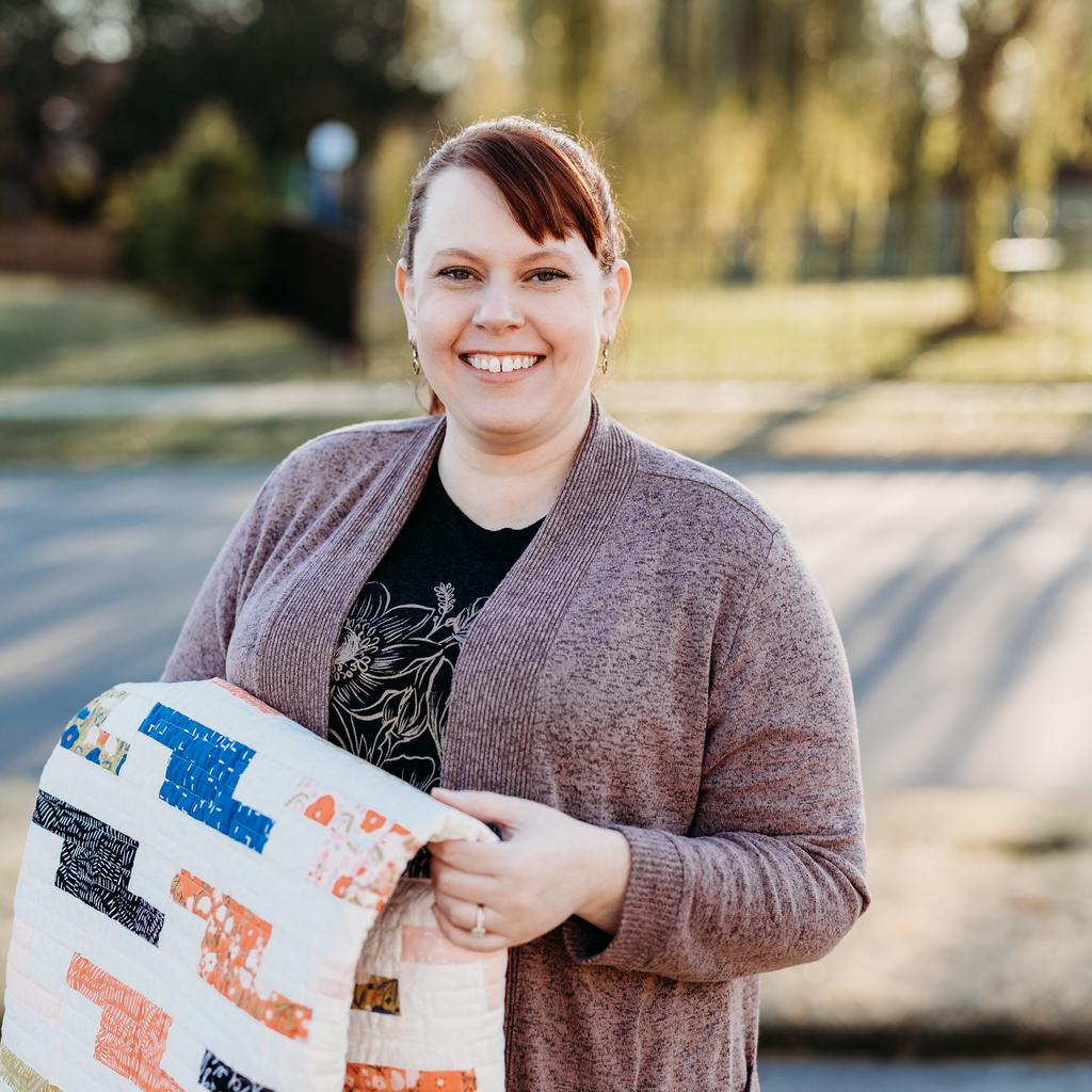 Jennifer Walters outside holding Aspiration quilt