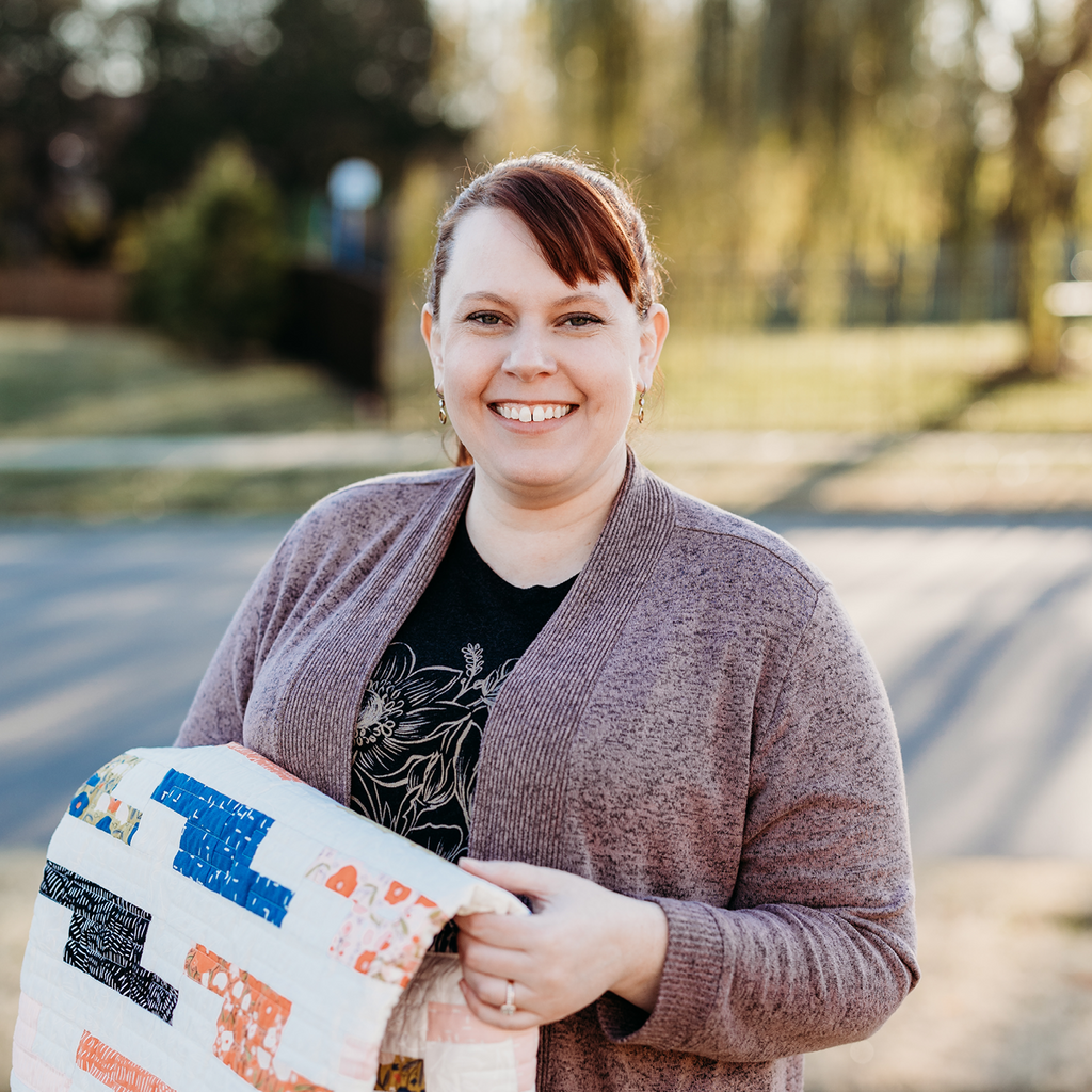 Manderley Makes Jennifer Walters outside holding Aspiration quilt